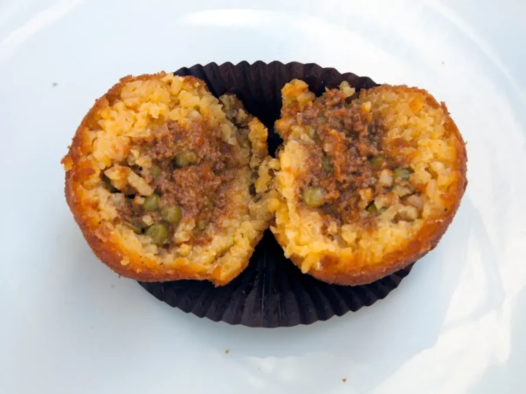 Arancina al ragù aperta con carne macinata e piselli